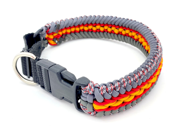a paracord dog collar made of red, gold, and gray paracord, and black webbing and hardware