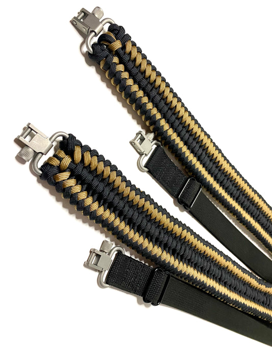 two rifle slings made in the sanctified covenant weave with black and tan paracord, black webbing and silver trilock swivels.