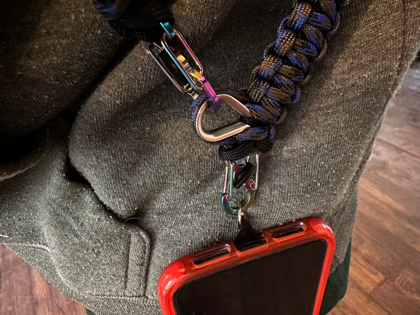 a close up of a person wearing a cross body paracord lanyard attached to a phone