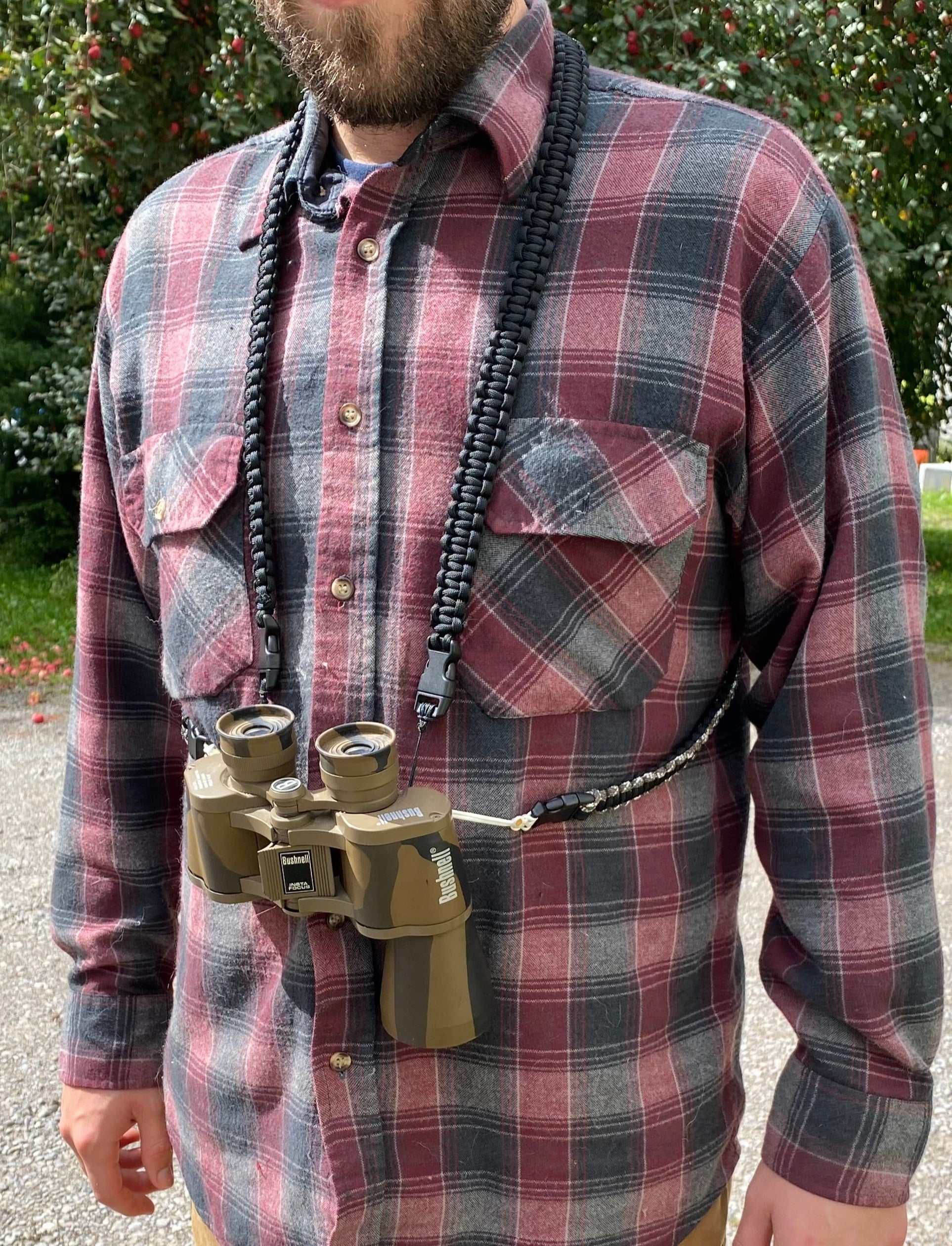 the front of a man wearing a paracord binocular harness