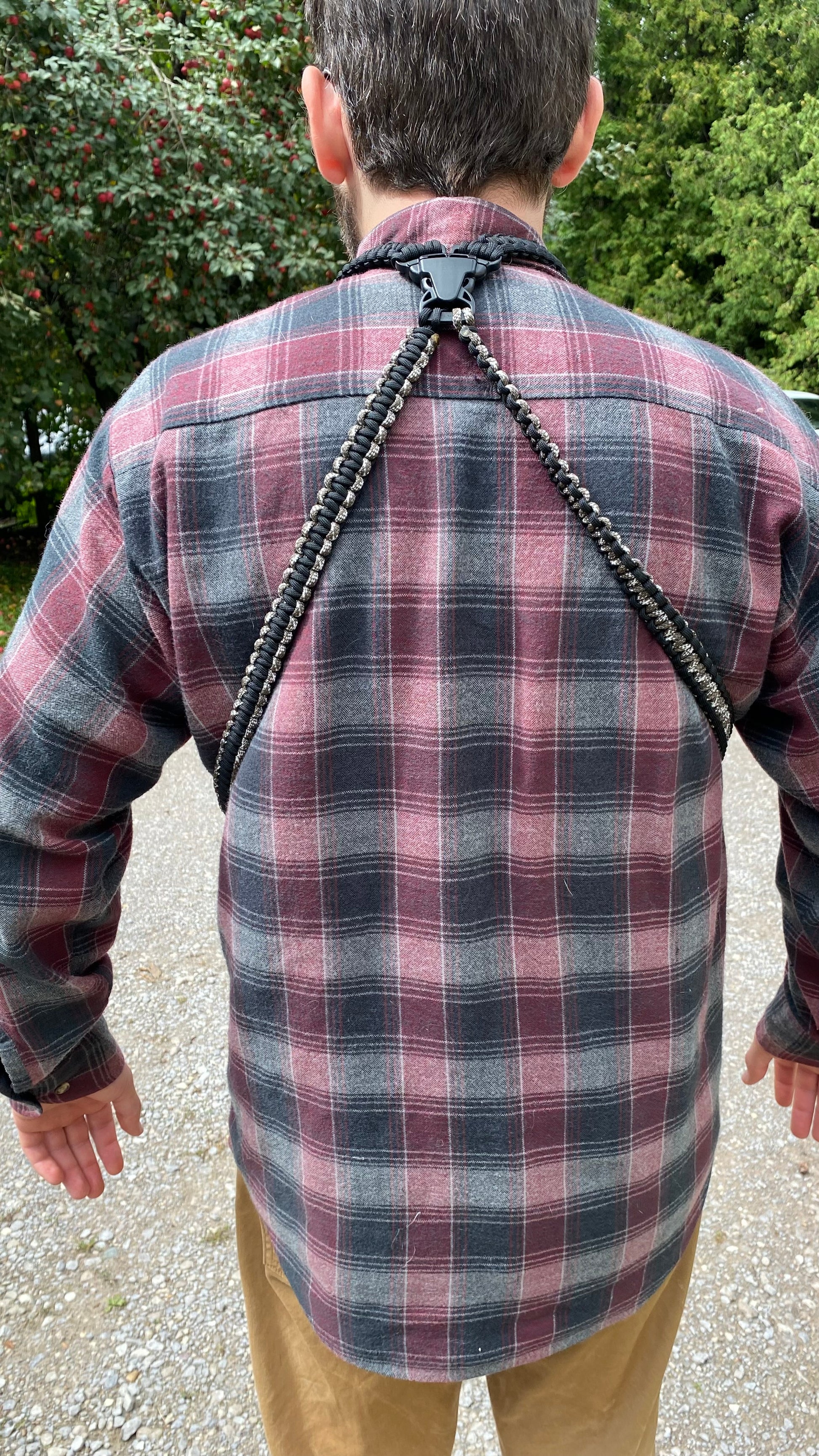 a man wearing a paracord binocular harness
