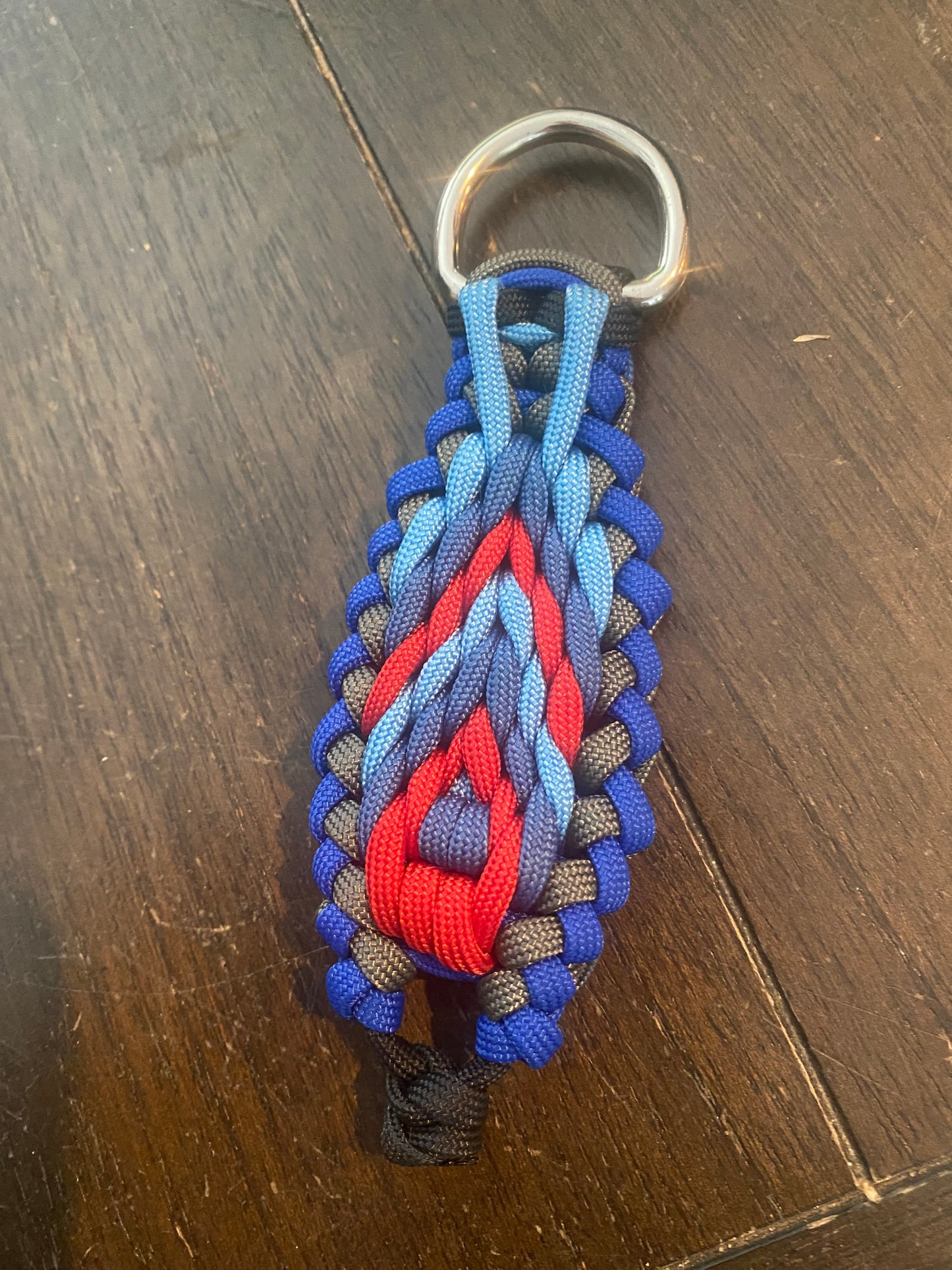a sanctified cherokee trail key chain crafted in 550 paracord with blue and red and grey cord