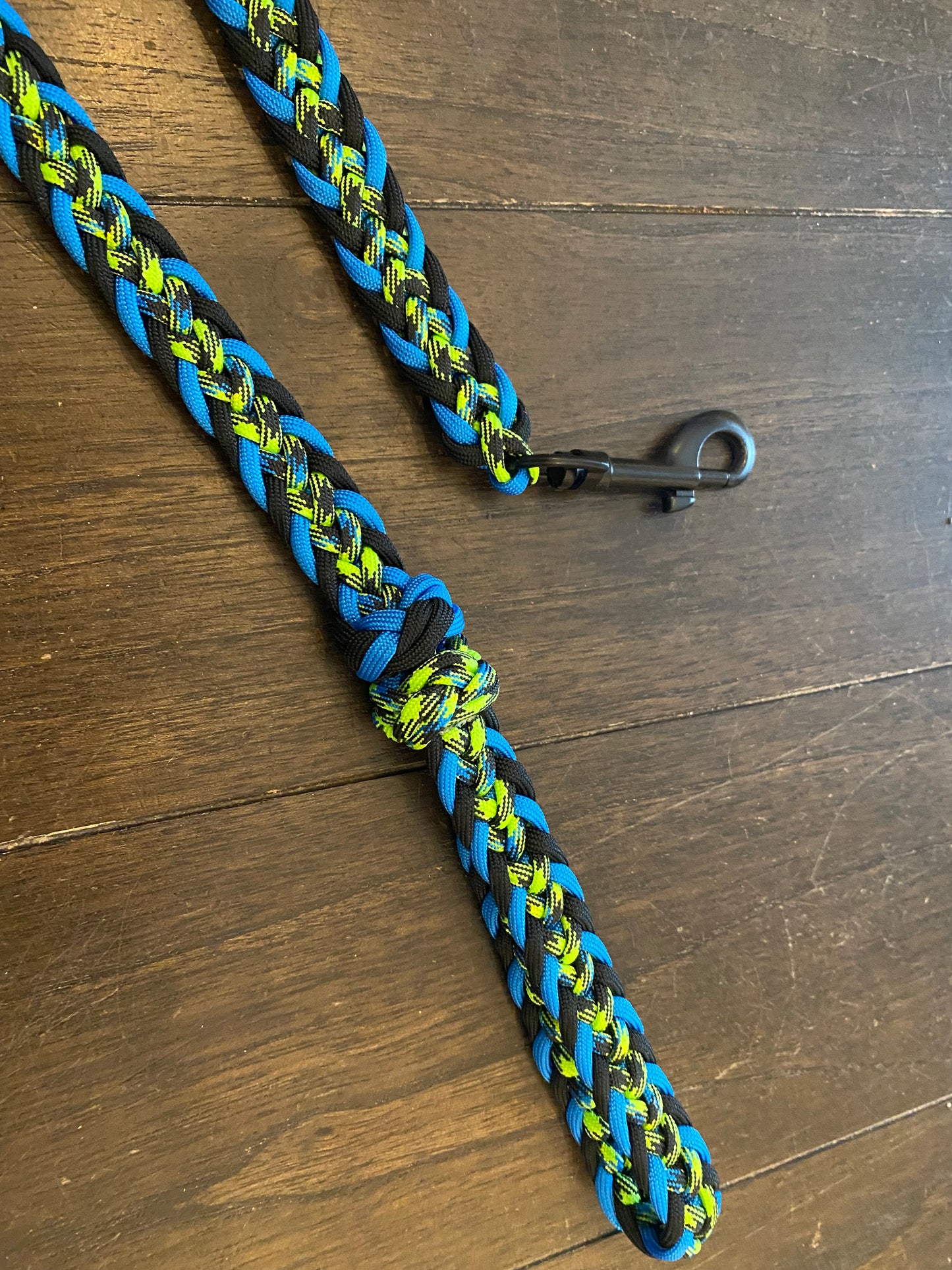 a Japanese flat weave leash crafted out of blue, black, and neon green 550 paracord