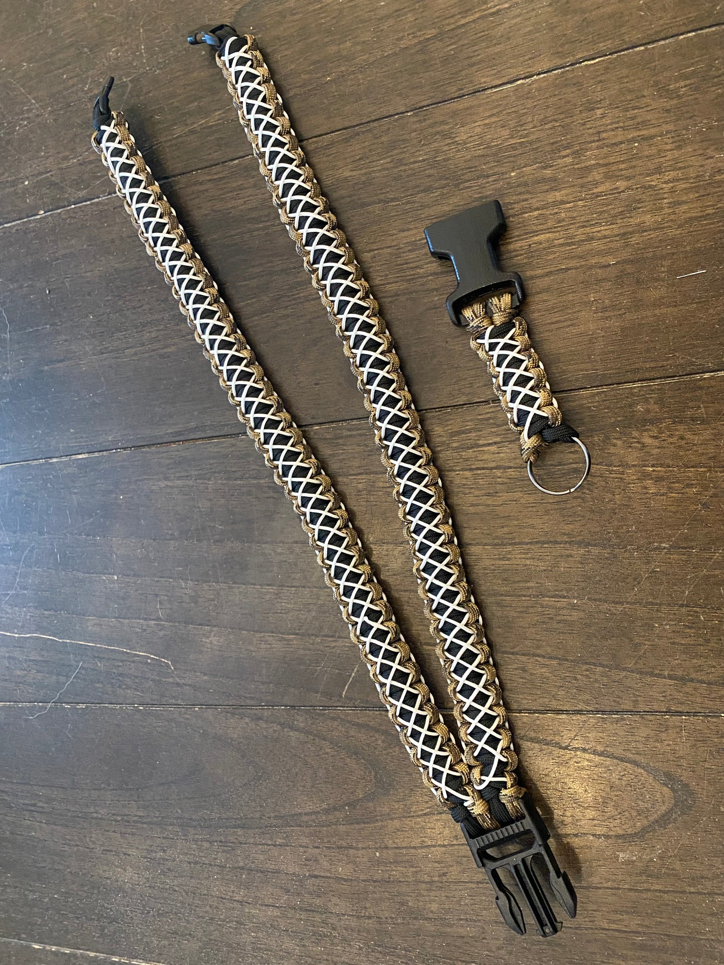 a general lanyard crafted in the cobra weave in FDE camo and black 550 paracord and white microcord