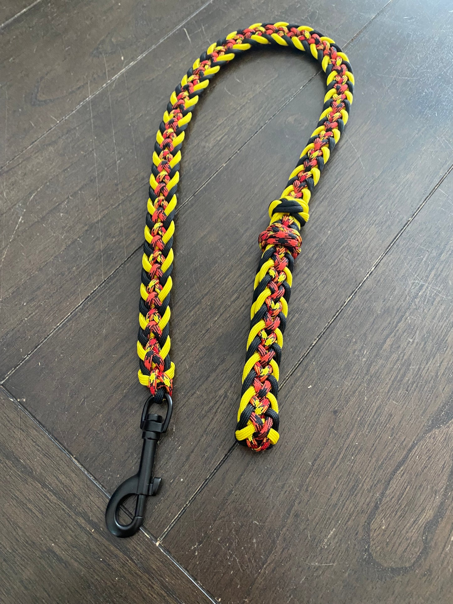 a traffic dog leash made in the Japanese flat weave with yellow, black, red and patterned paracord in matching colors