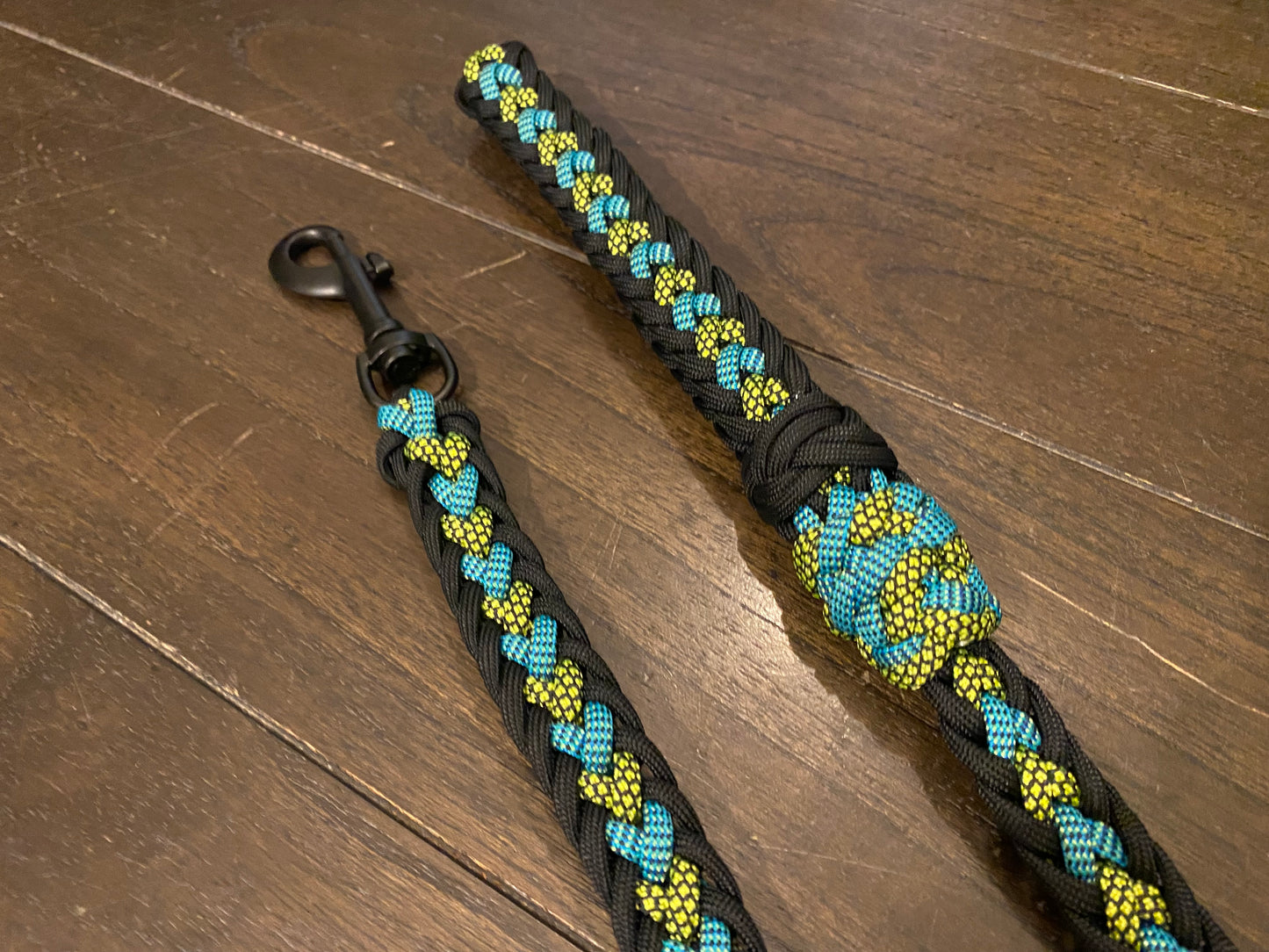 a dog leash made in the Japanese flat weave with teal color-changing, neon yellow and black diamond, and black 550 paracord