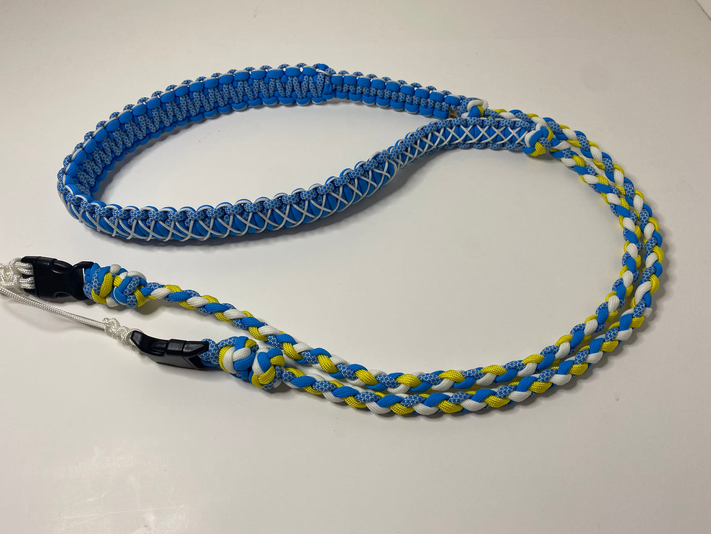a fancy dual-weave paracord binocular lanyard with buckles made in light blue, yellow, and white cord; the neckband is stitched with white microcord.