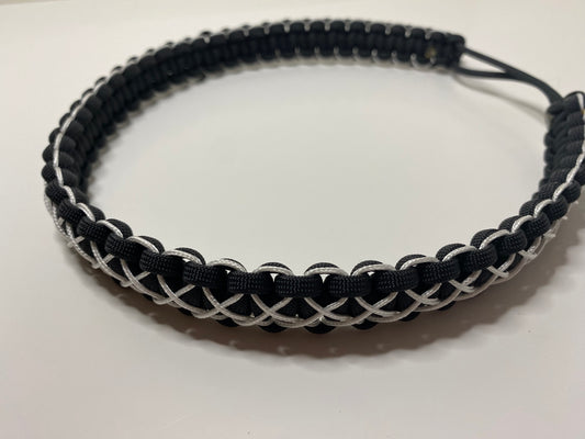 a hat band made in the cobra weave and made in black paracord and stitched with white microcord.