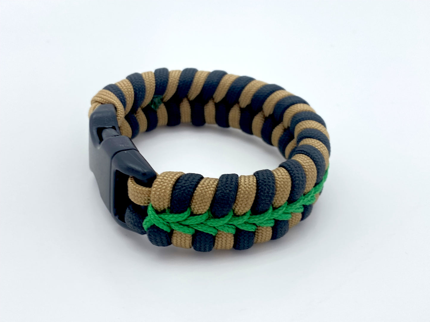 a fixed fishtail paracord bracelet made with black and tan 550 paracord and stitched with green 95 cord