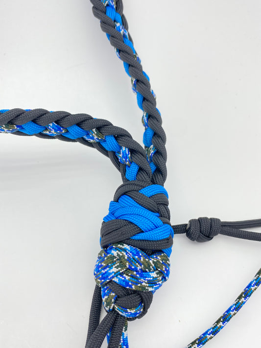 a closeup of the termination knots of a paracord game call lanyard made with black, blue and terra paracord.