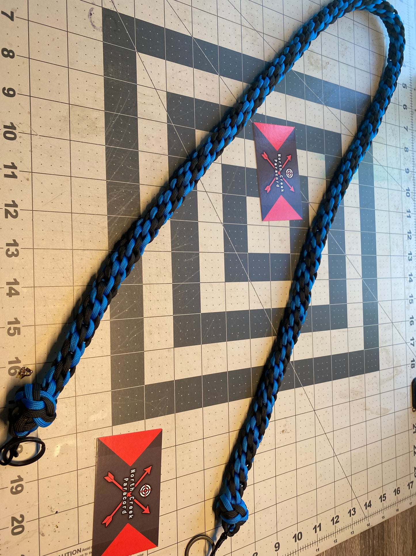 a binocular lanyard crafted with the Japanese round braid in blue and black and black hardware