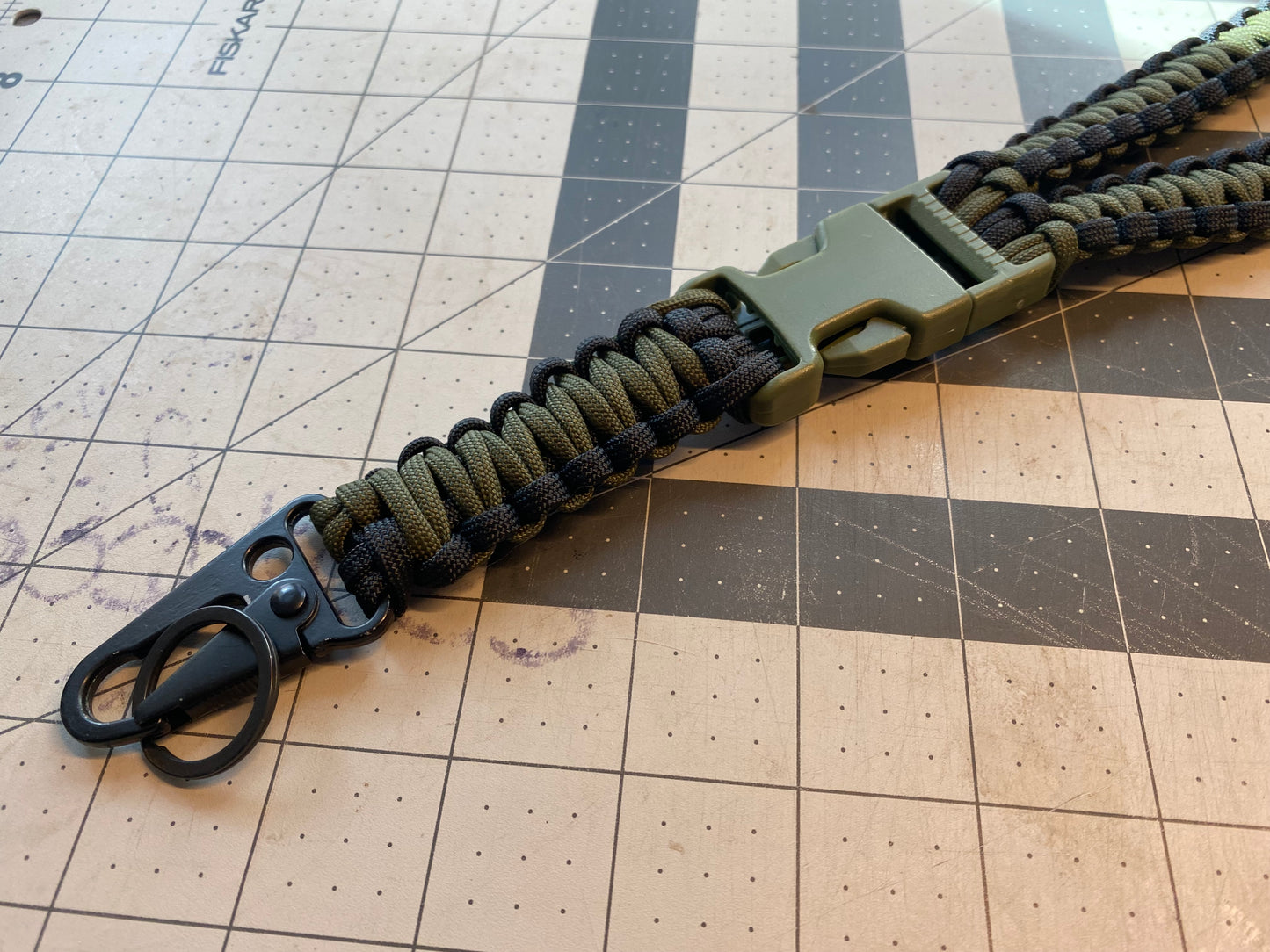 a tactical general lanyard crafted in the cobra weave with a OD green and black color scheme