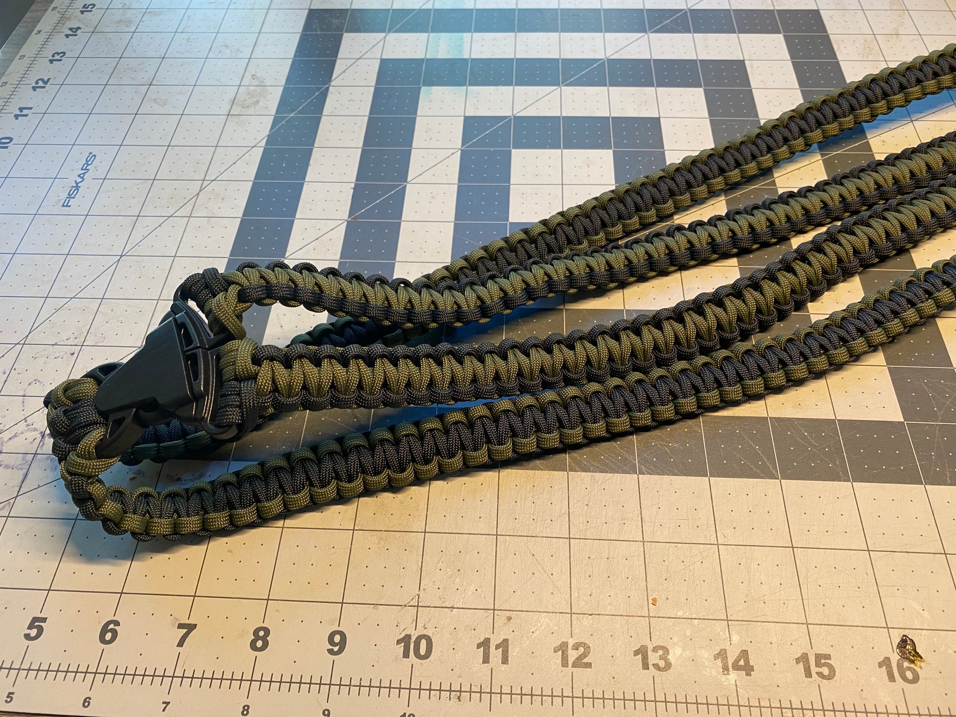 a binocular harness crafted from OD green and black 550 paracord