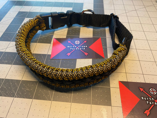a pet collar built in the modified sanctified weave in gold and tan black diamond paracord and a black center stitching.