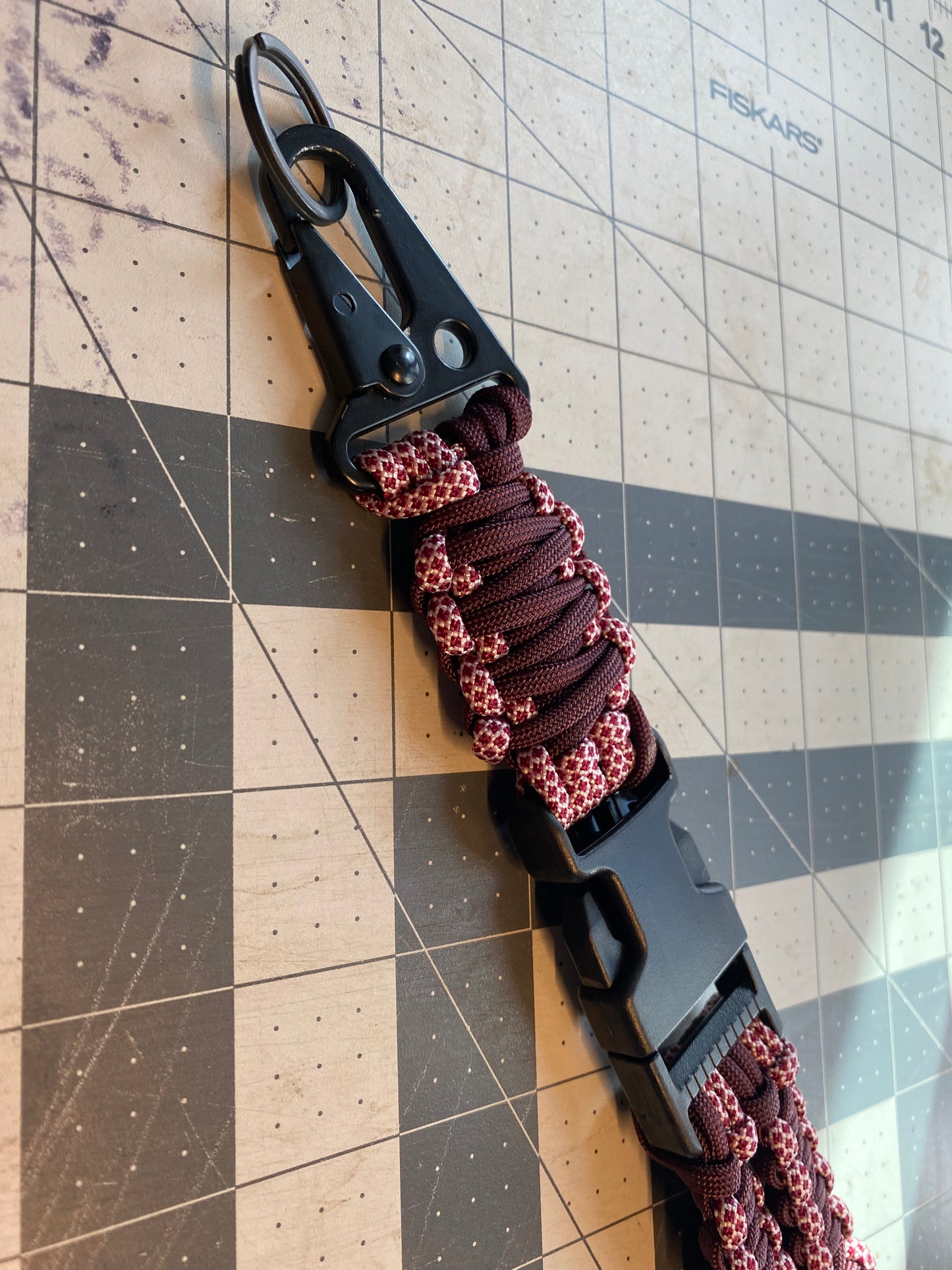 a tactical general lanyard crafted in the cobra weave with a dark red and burgundy color scheme