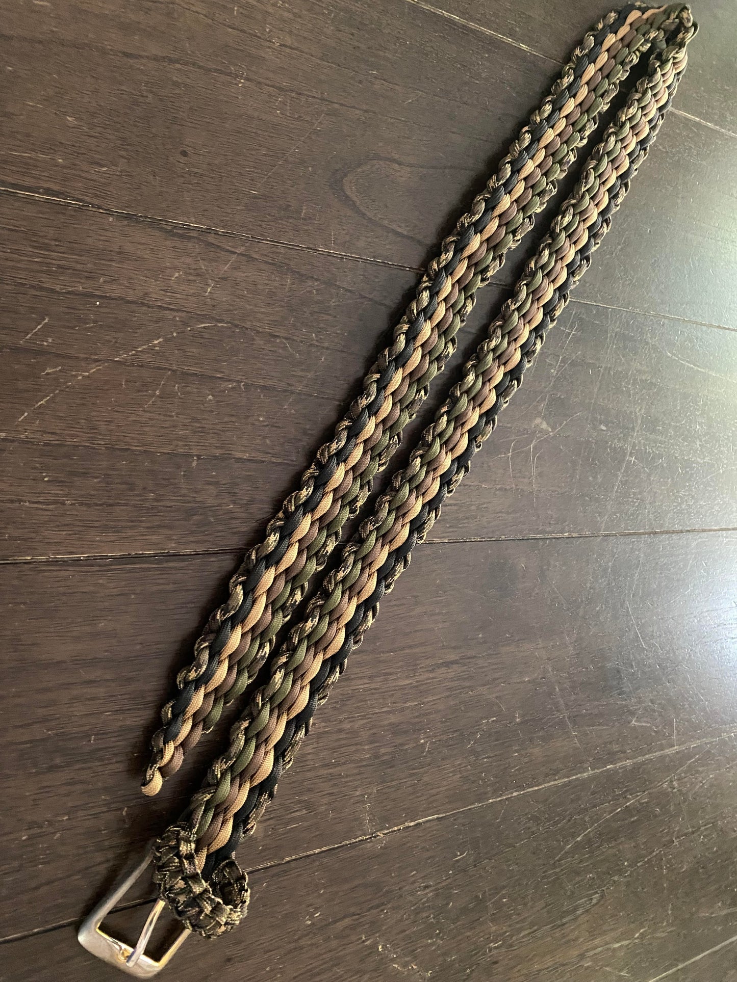 a belt made with various earthy shades and camo paracord a finished off with a old reclaimed buckle