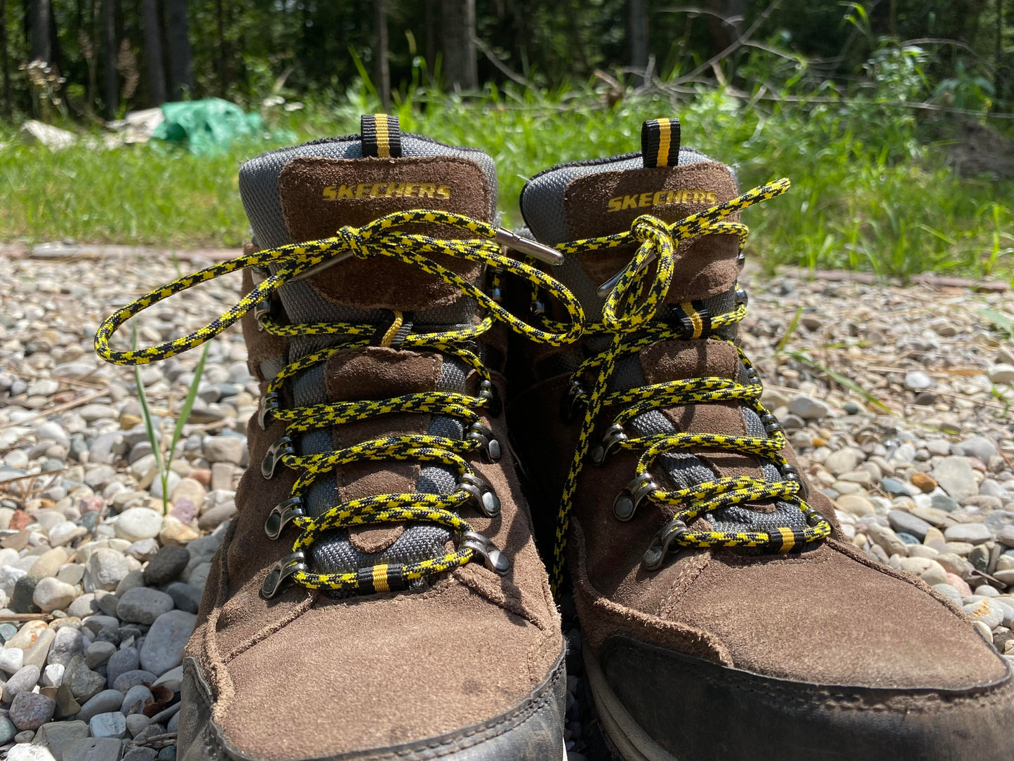 yellow and black 550 paracord bootlaces laced on a pair of boots sitting in the rock garden