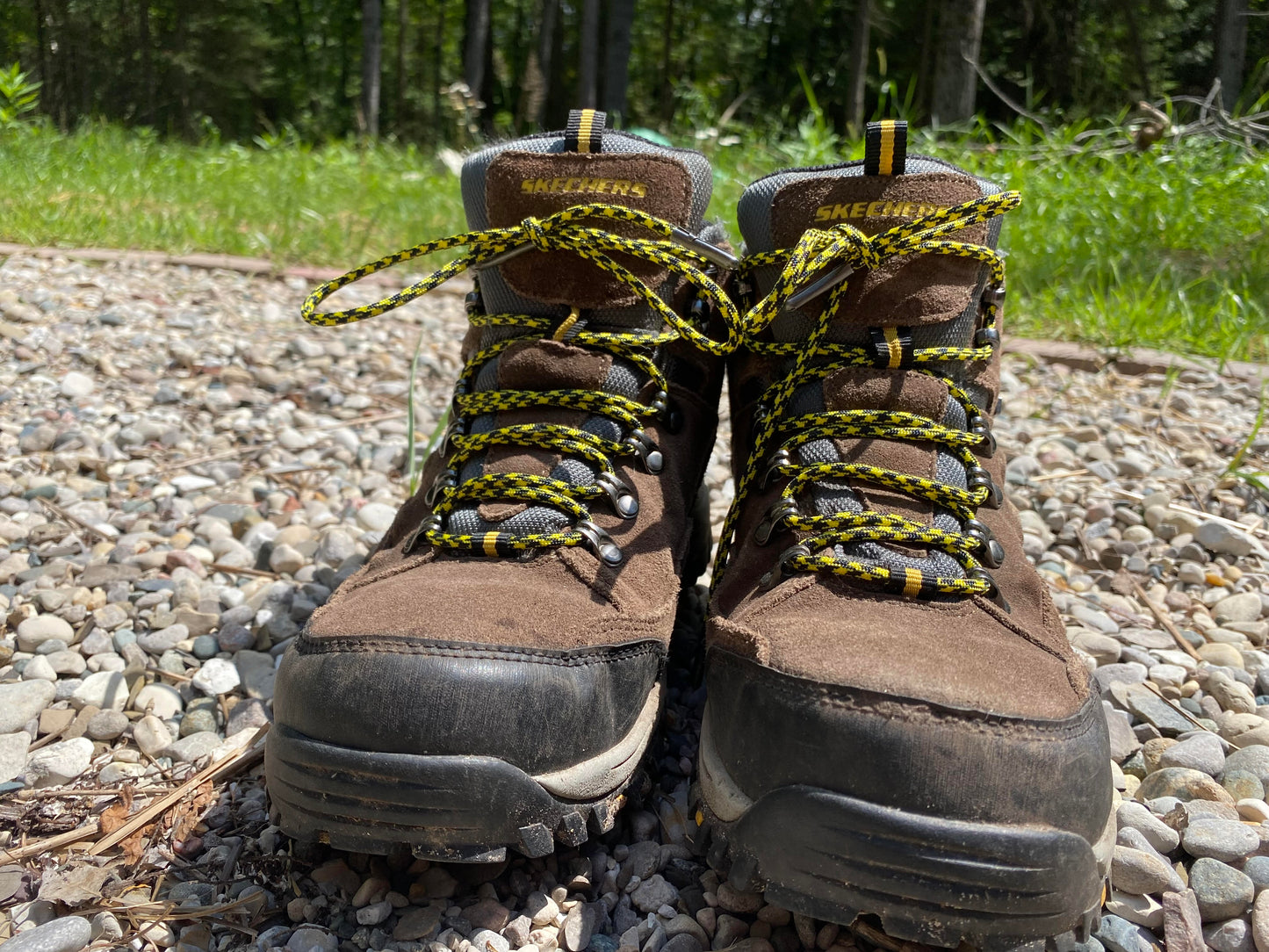 yellow and black 550 paracord bootlaces laced on a pair of boots sitting in the rock garden