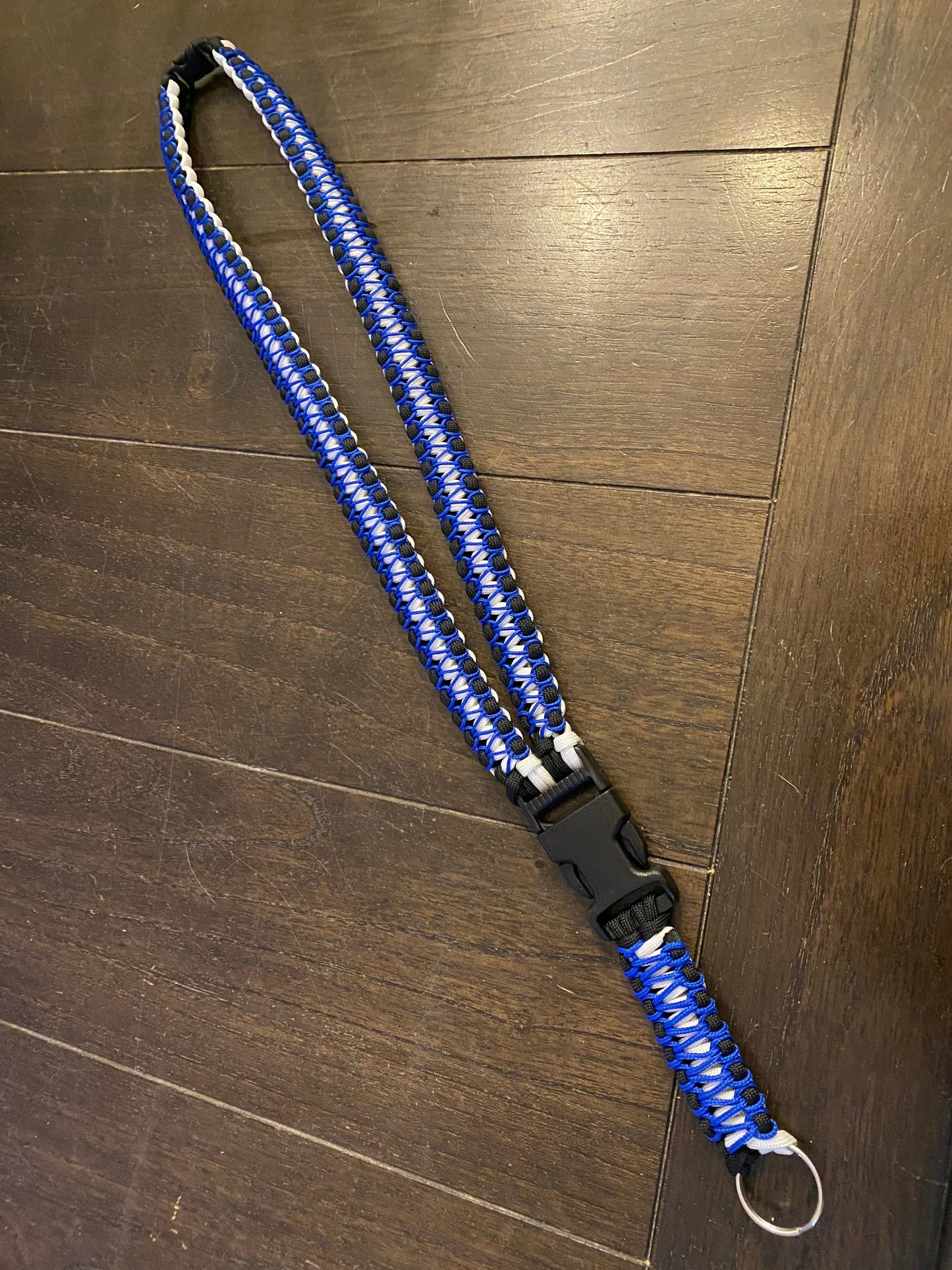 a herringbone stitched cobra lanyard in black and white 550 paracord and ultramarine blue microcord