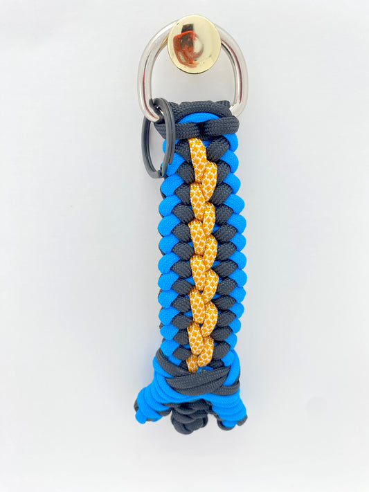 a modified sanctified woven key chain in blue, black, and honeycomb 550 paracord then finished with a footrope knot and snake knots