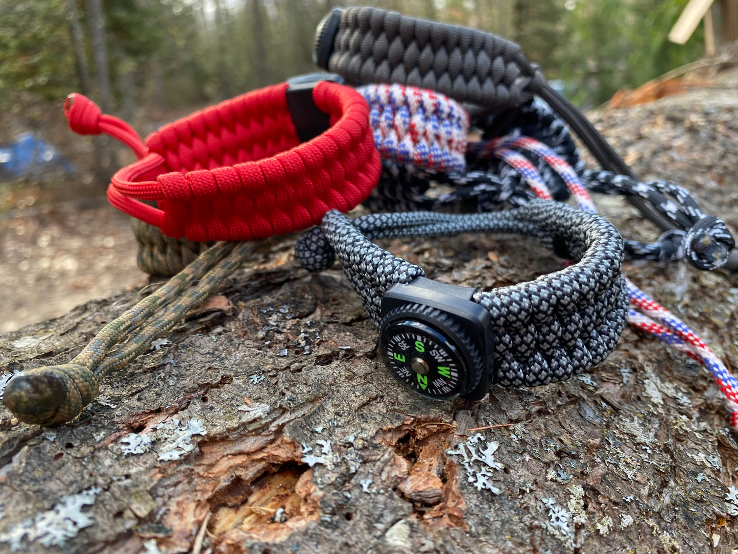 a bunch of adjustable trilobite bracelets with compasses and made of paracord.