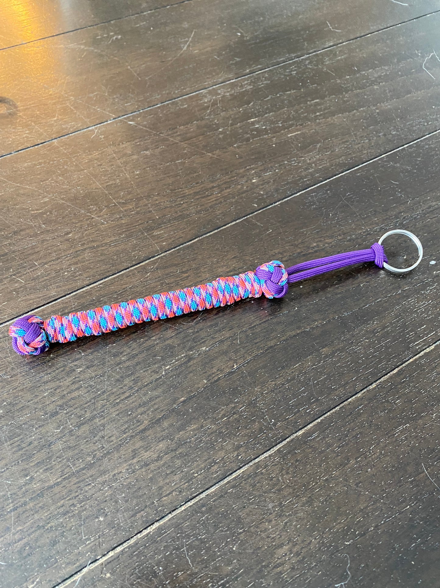a small lanyard made with purple, pink and blue 550 paracord and two diamond knots.