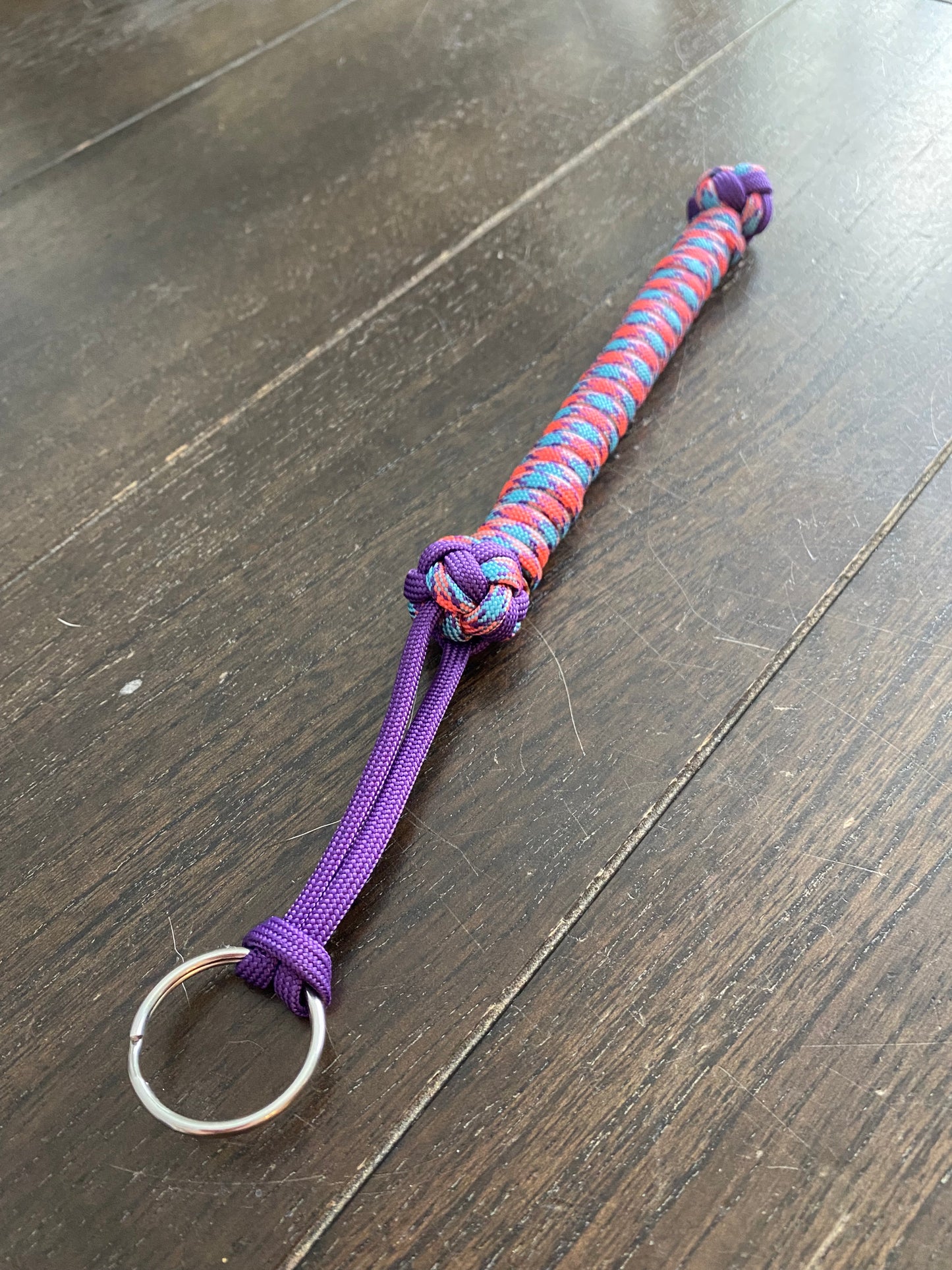 a small lanyard made with purple, pink and blue 550 paracord and two diamond knots.
