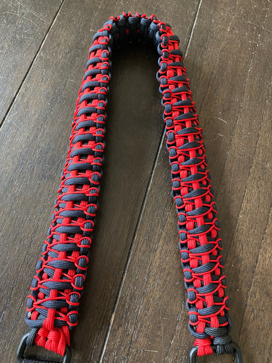 the shoulder portion of a paracord bow sling crafted in black and red paracord and microcord.