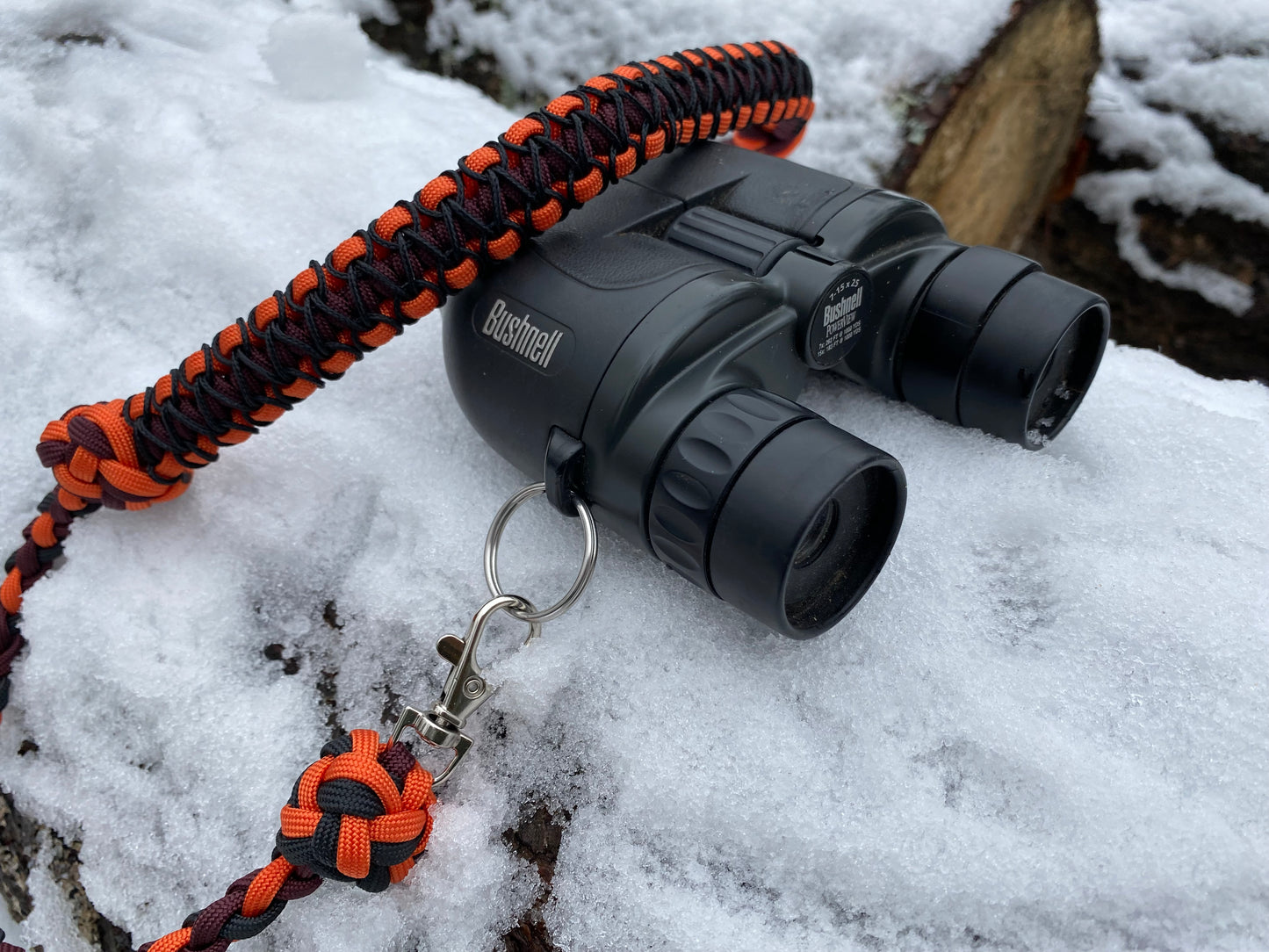 a 4-strand and cobra binocular lanyard attached to binoculars.