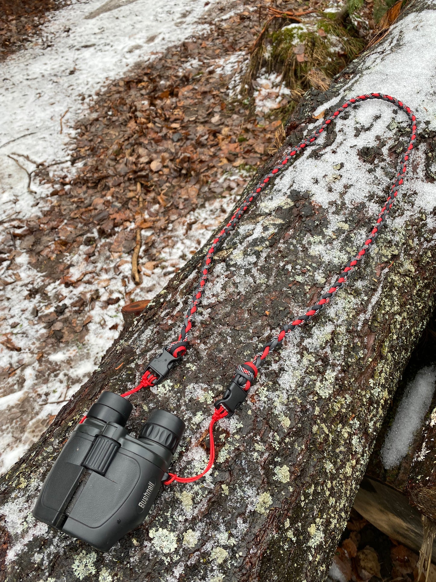 a 4-strand binocular lanyard attached to binoculars.