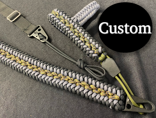 a no drill gun sling made with black, grey, and camo 550 paracord and black hardware and webbing.