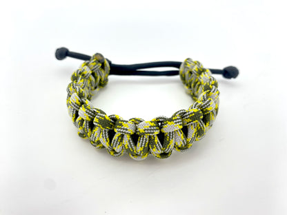 an adjustable cobra 550 paracord bracelet made with black and multicolored yellow, gray, and olive green paracord