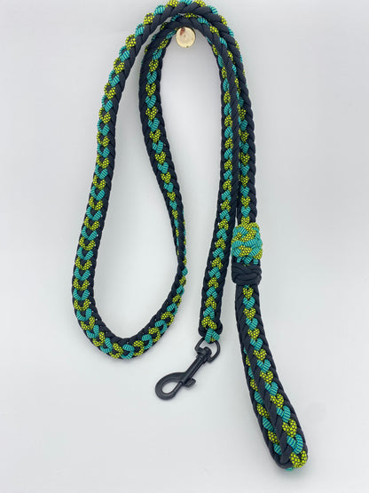 a fancy 550 paracord leash that is made in black, teal, and neon yellow diamond patterned paracord.