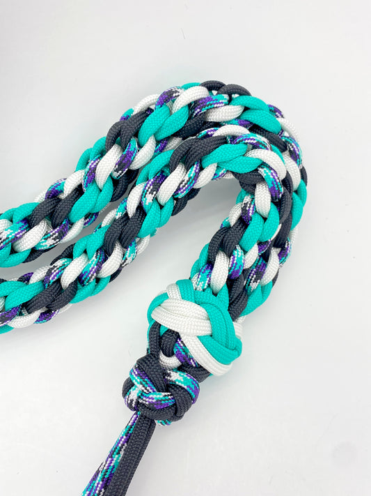 a close-up of a paracord game call lanyard showing the two footrope knots used to terminate the round weave.