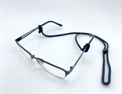 a pair of eye glasses with a black 550 paracord eyeglass retainer attached in a clean white background