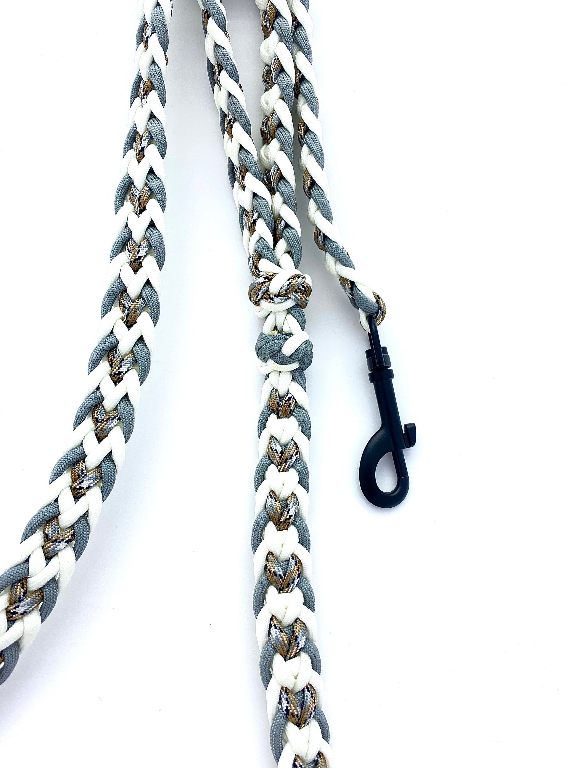 a paracord leash made out of 550 paracord made in white, gray, and desert camo colors